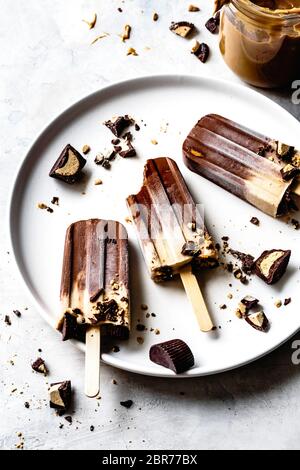 Peanut butter cup chocolate fudge popsicles on a plate. Stock Photo