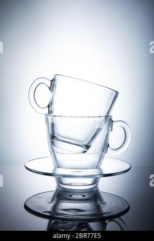 Two isolated transparent tea cups with saucers. Stock Photo