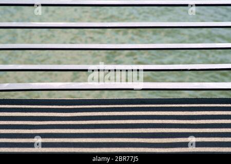 The close-up of the cross struts of a bridge railing casting symmetrical shadows. Stock Photo