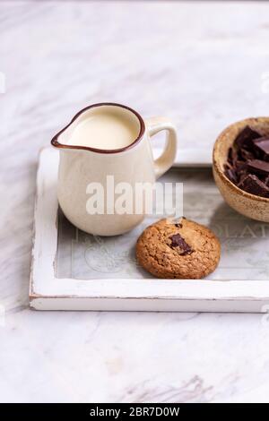 Oats chocolate chip cookie and a jug of milk on a tray Stock Photo