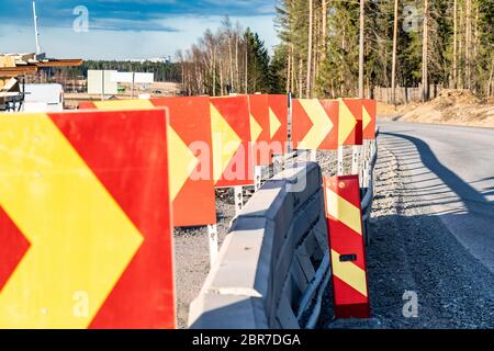 Close up photo at row of warning direction drive signs, temporarily placed at corner of road under construction to avoid collision with concrete fence Stock Photo