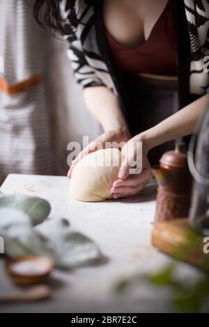 A woman preparing dough in a kitchen Stock Photo