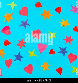 collage of multicolored stars and hearts cut from papers on blue turquoise pastel paper Stock Photo