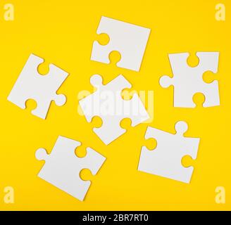 blank white big puzzles on yellow background, flat lay Stock Photo