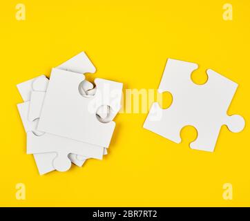 blank white big puzzles on yellow background, flat lay Stock Photo
