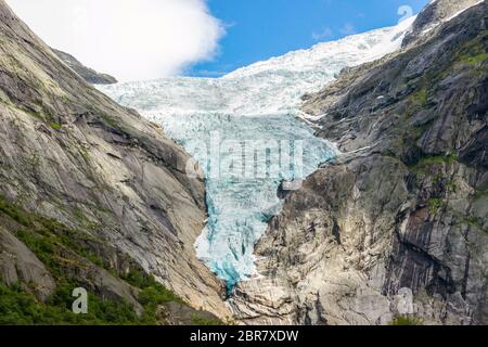 Briksdal or Briksdalsbreen glacier with melting blue ice, Norway nature landmark and its lake of milky melting water. Norway glacier in Jostedalsbreen Stock Photo