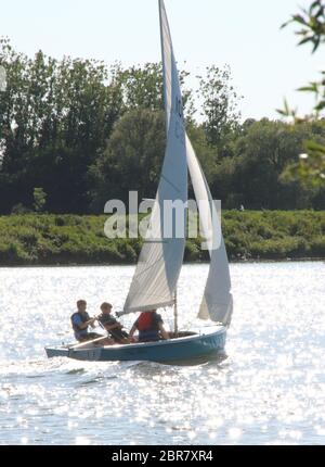 London, UK. 20th May, 2020. Men sailing on a dinghy at Priory Country Park Lake following the ease of restrictions on forms of exercise during the COVID 19 Lockdown as temperatures hit 27 degrees C, the hottest day of the year in the UK. Credit: Keith Mayhew/SOPA Images/ZUMA Wire/Alamy Live News Stock Photo