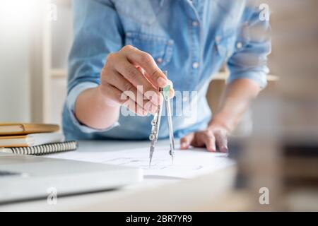 Architects engineer discussing at the table with blueprint - Closeup on hands and project print. Stock Photo
