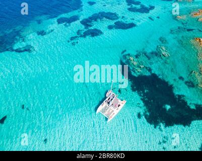 Drone aerial view of catamaran sailing boat in Maddalena Archipelago, Sardinia, Italy. Maddalena Archipelago is a group of islands between Corsica and Stock Photo