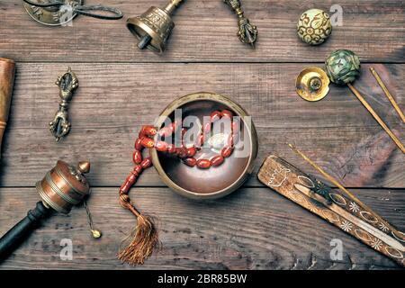 Copper singing bowl, prayer beads, prayer drum and other Tibetan religious objects for meditation and alternative medicine Stock Photo