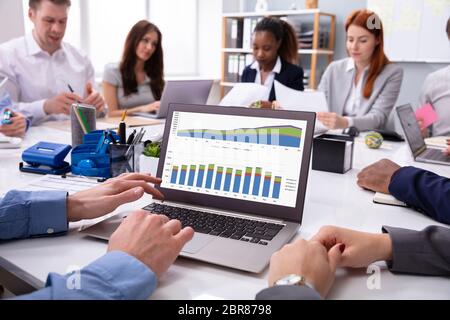 Close-up Of A Businessman Analyzing The Graph On Laptop In The Meeting Stock Photo