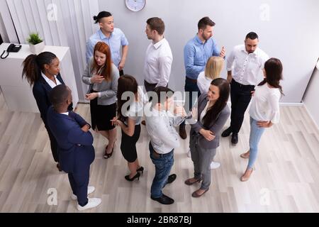 Professional Diverse Businesspeople Discussing With Each Other In Corporate Office Stock Photo