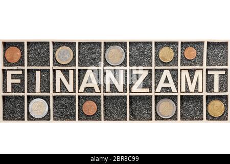 Plywood letters arranged in a collecting box with black decorative sand representing the word FINANCE and nine different euro coins in adjacent compar Stock Photo