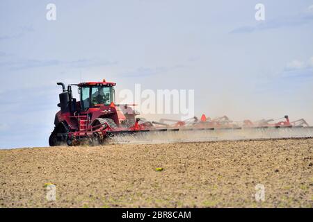 Burlington, Illinois, USA. Farmer in tractor preparing his fields for spring planting on a farm in northeastern Illinois. Stock Photo