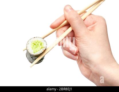 female hand with disposable chopsticks holds kappa maki sushi roll with cucumber isolated on white background Stock Photo