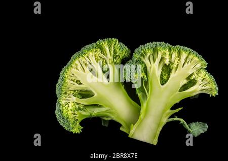 Broccoli florets cut in half on a black background Stock Photo