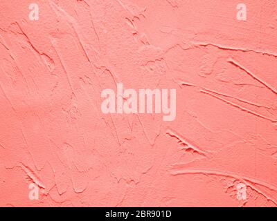 Vintage or grungy background of cement texture in Living Coral color of Year 2019. Decorative plaster effect on wall in Living Coral colour. It is a c Stock Photo