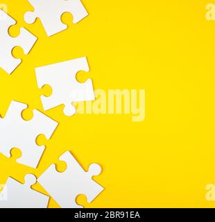 blank white big puzzles on yellow background, flat lay Stock Photo