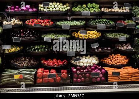 A wide-view shot of an abundance of fresh vegetables on display at a market stall.