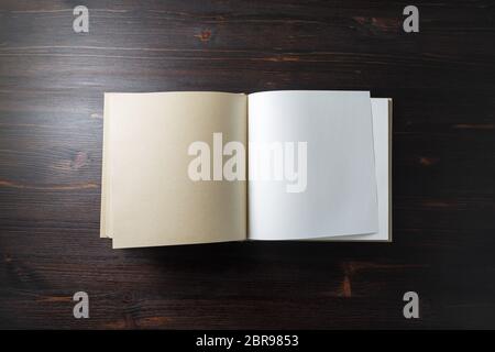 Photo of opened blank square book on wooden background. Template for design presentations and portfolios. Flat lay. Stock Photo