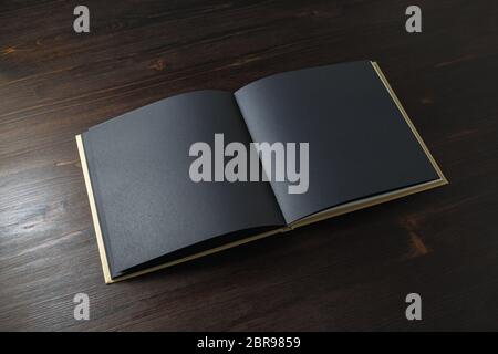 Photo of opened book with blank black pages on wooden background Stock Photo