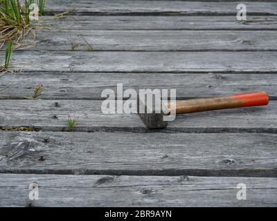 sledgehammer on the boards old bridge sticking rusty nails Stock Photo