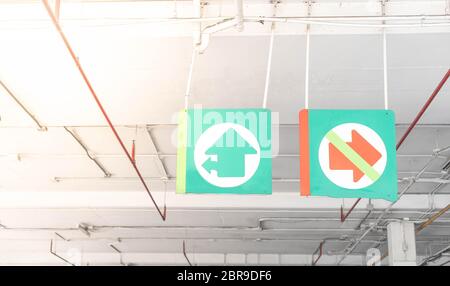 The green metal exit and in sign hanging on the outside of the parking car at the department store. Stock Photo