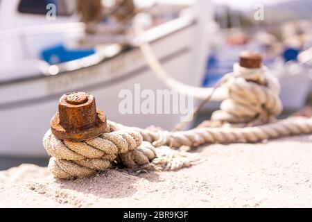 Close up of a rope knot holding empty fisherman boat moored in port, Zante, Greece