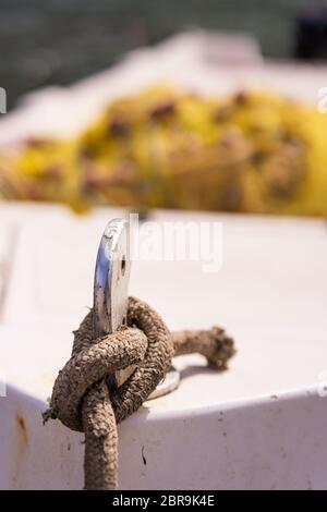 Close up of a rope knot holding empty fisherman boat moored in port, Zante, Greece