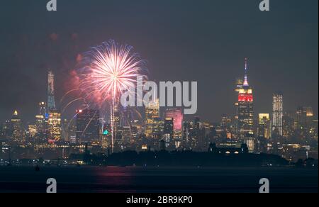 Fireworks are being set off from barges on the river between Jersey City and New York. Stock Photo