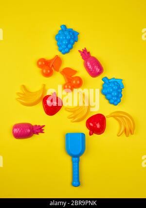children's plastic multi-colored toys laid out in the form of a Christmas tree, festive backdrop Stock Photo