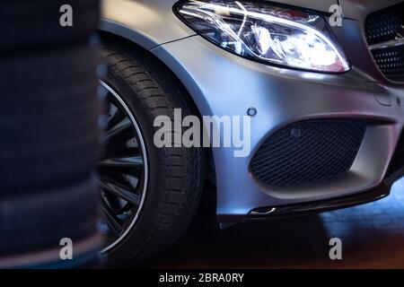 Car in a garage for maintenance, oil/tyre change (shallow DOF; color toned image) Stock Photo