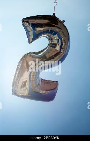 number 2 helium filled balloon against a blue sky Stock Photo