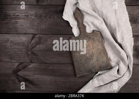 old wooden kitchen chopping boards and a gray towel on a brown table, view from the top Stock Photo