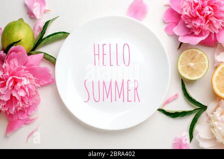 Top view of white empty plate over spring flowers. Flat lay, spring summer season holiday, femenine wedding table setting, valentine, woman, mother da Stock Photo
