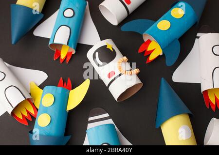 School kindergarten crafts, paper spaceship, shuttle, astronaut on black background with copy space for text. Party concept handcraft, diy, creative i Stock Photo