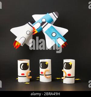 School kindergarten crafts, paper spaceship, shuttle, astronaut on black background with copy space for text. Party, start up launch concept, diy, cre Stock Photo