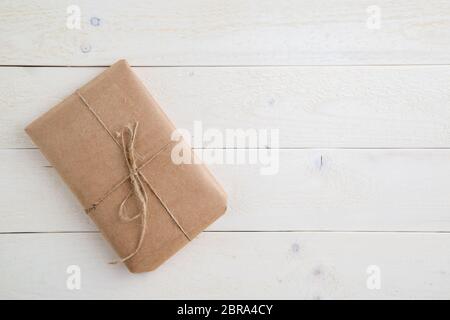 parcel,gift Packed in eco-friendly paper on light wooden background. the view from the top Stock Photo