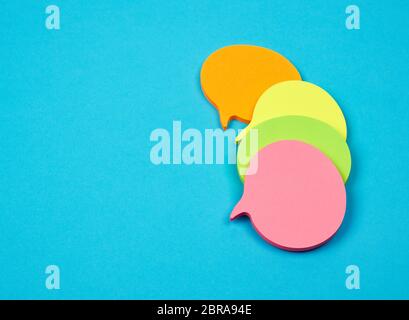 stack of multicolored empty paper stickers in the form of clouds on a blue background Stock Photo