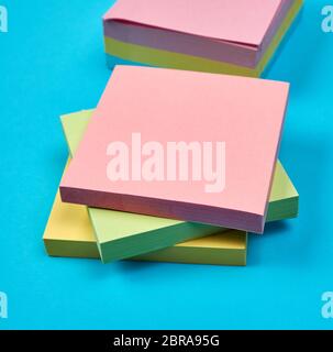 multicolored empty paper square stickers on blue background, close up Stock Photo