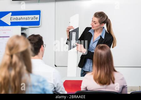 Teacher with class giving driving lessons explain traffic signs Stock Photo