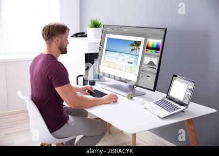 Designer Editing Photo On Computer In Office Stock Photo