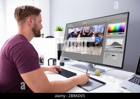 Designer Editing Photo On Computer In Office Stock Photo
