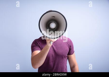 Close-up Of A Beard Man Shouting Through A Megaphone Against Gray Background Stock Photo