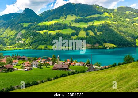 Swiss village Lungern with its traditional houses and old church tower Alter Kirchturm along the lake Lungerersee, canton of Obwalden, Switzerland Stock Photo