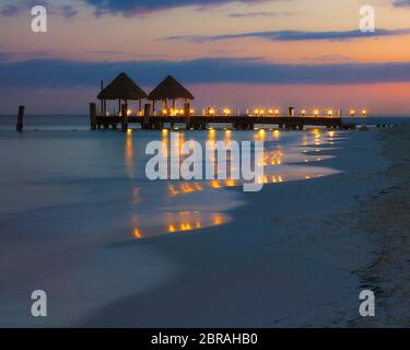 Palapas on the docks at dusk in Puerto Morelos, Quintana Roo, Mexico. Stock Photo