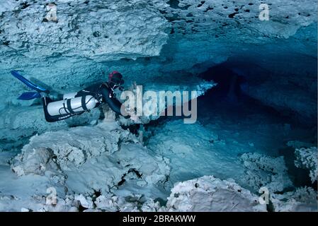 Technical sidemount diver on the cenote Calavera, know as the Temple of Doom with a strong halocline. Stock Photo