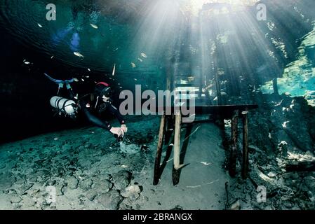 Sidemount technical diver swimming at the entrance of the cenote Dreamgate in Mexico. Stock Photo