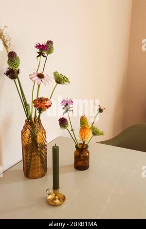 Two vases with flowers on the table retro modern design with white wall close-up Stock Photo