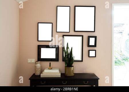 collection of various blank black frames on wall with modern decoration, green plant in a lovely home retro design Stock Photo